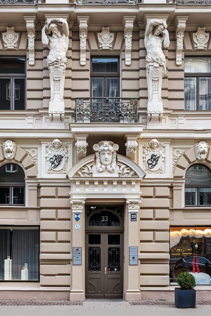 Dramatic stone sculptures and female heads on the roofline of Elizabetes 33, Riga